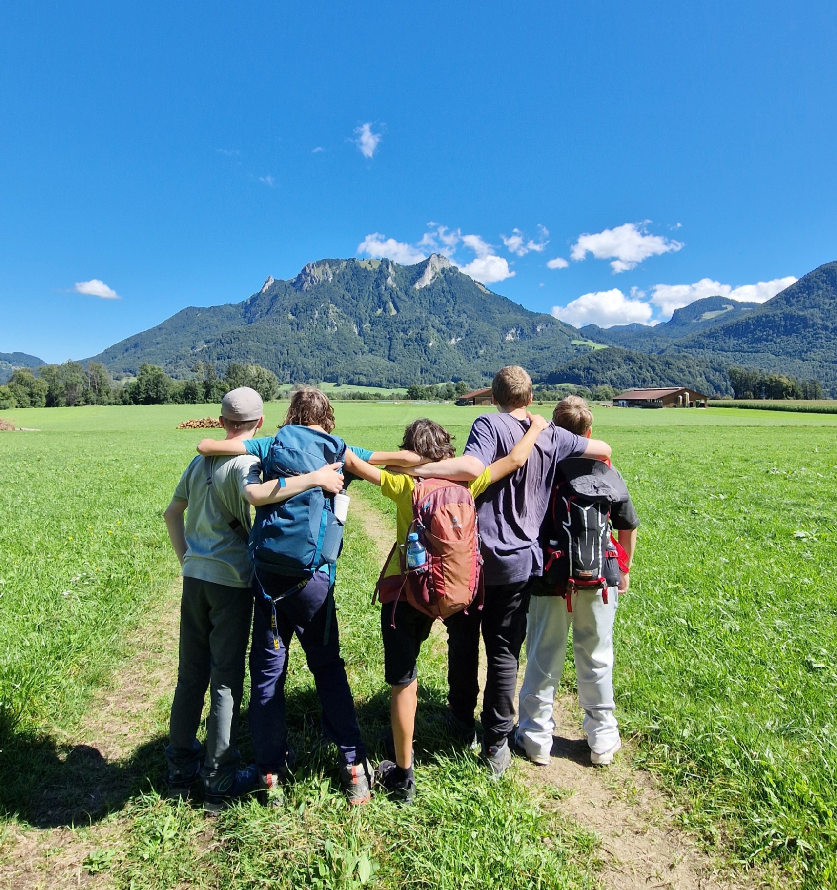 Jugendliche blicken gemeinsam Richtung Berge